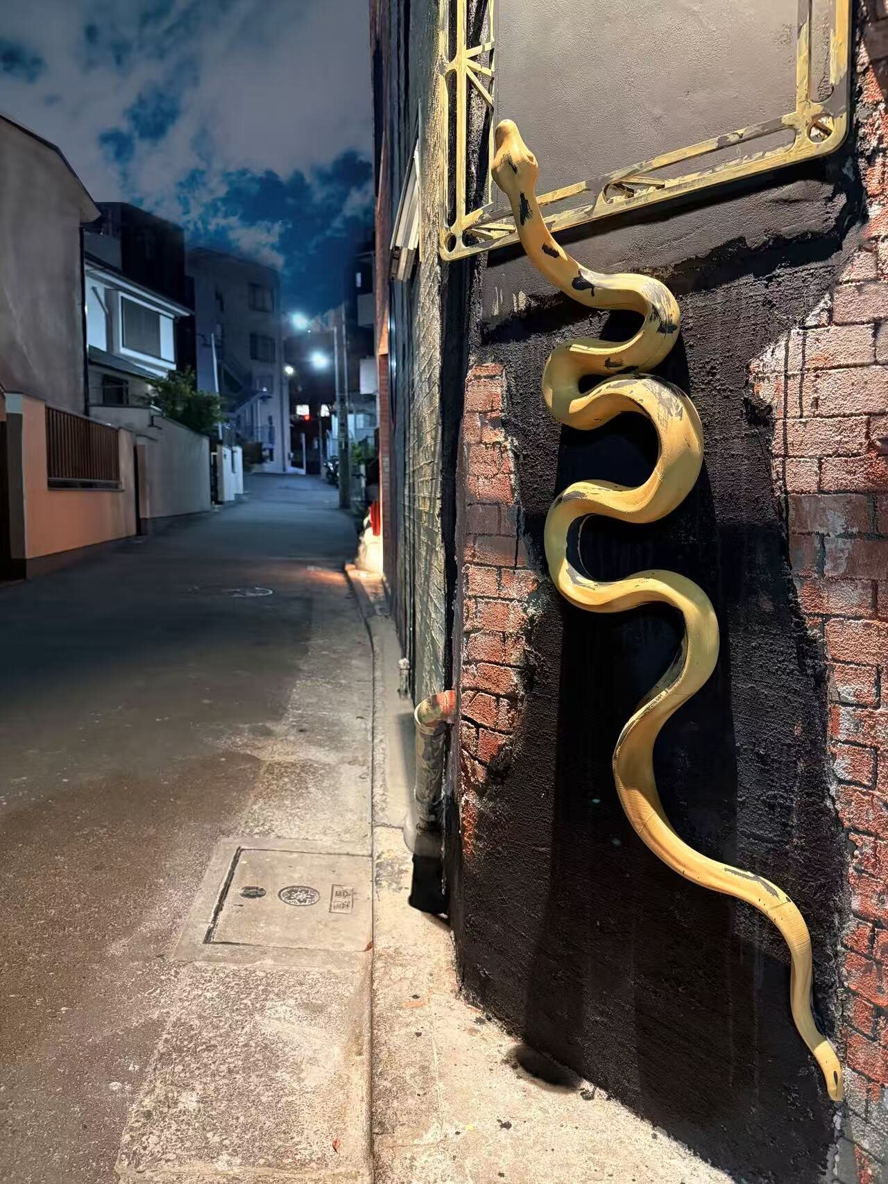 Xuanwu Art Space at night — the gold serpent sculpture along the quiet alley